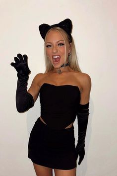 a woman dressed up as a cat with her hands in the air and wearing black gloves