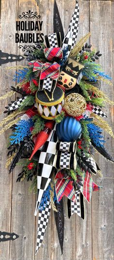 a christmas wreath made out of black, white and red ribbons on top of a wooden table