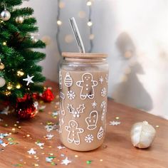 a cup with a straw in it sitting on a table next to a christmas tree