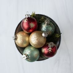 a bowl filled with christmas ornaments on top of a table