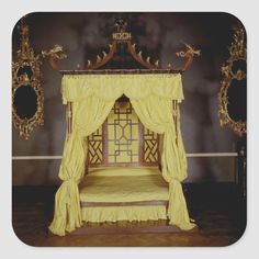 a yellow canopy bed sitting on top of a hard wood floor