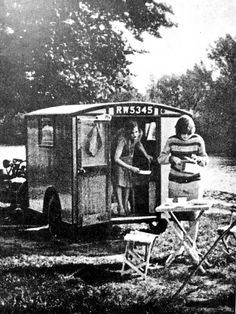 an old black and white photo of two women standing in a small trailer with the door open