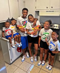 a group of young children standing next to each other in front of a kitchen sink