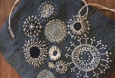 a piece of cloth with silver decorations on it sitting on top of a wooden table