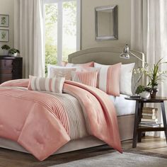 a bed with pink and white comforters in a bedroom