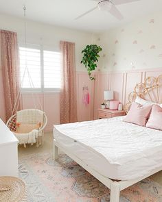 a bedroom with pink walls and white furniture