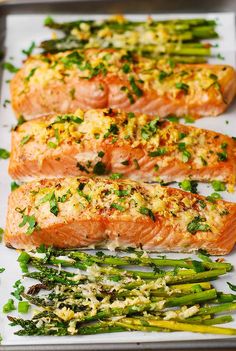 salmon and asparagus on a baking sheet with seasoning sprinkles