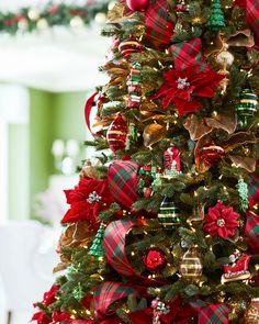 a christmas tree decorated with red, green and gold bows