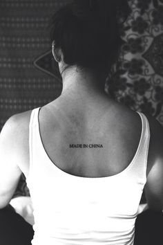 a woman with a tattoo on her back that reads made in china