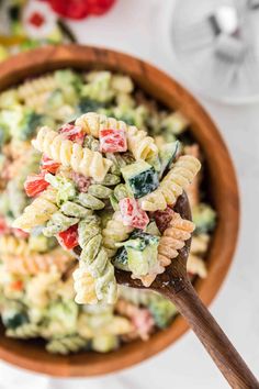 a wooden spoon filled with pasta salad