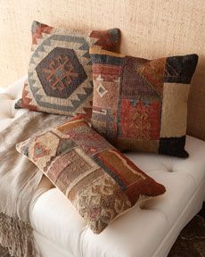 four decorative pillows on a white bench