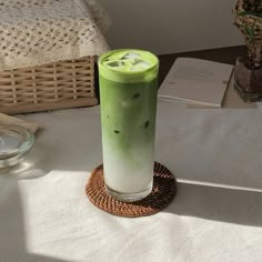 a green drink sitting on top of a table