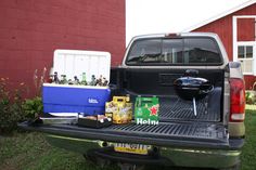 the back end of a pickup truck with beer and snacks in it's bed