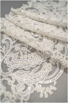 "Heavy hand beaded bridal lace trim with ornate pattern ❀❀ CHARACTERISTICS ❀❀ Embroidered on nylon tulle base Yarn: Rayon Color: off-white-ivory 3D Flowers: No Sequins/Beads: Yes (sequins + beads) Cording: No Listed per- 1 yards (yds) / 91,44 cm (0,91 Meter) - if you order more than 1yds, you'll get the lace in one continuous full piece.  ❀❀ MEASUREMENTS ❀❀  Width: 20-26cm/ 7.8\" - 10.2\"  ❀❀ SAMPLE SWATCHES❀❀ If you want to check the color and quality, you can order a swatch here (READ DESCRIPTION OF THE LISTING  https://www.etsy.com/listing/733242442/sample-swatch-please-read-description?ga_search_query=sample&ref=shop_items_search_1&crt=1 Please note, that it can happen, that till you get your lace sample with air mail, the lace could be sold in this time.  ❀❀ We only sell by FULL yds! Pearl Embroidered Lace Fabric For Ceremonies, Ceremony Lace Fabric With Pearl Embroidery, Elegant Wedding Fabrics With Intricate Embroidery, Elegant Wedding Fabric With Intricate Embroidery, Lace Embroidered Fabric With Lace Trim For Wedding, Wedding Embroidered Lace Fabric With Lace Trim, Elegant Wedding Lace Fabric And Notions, Elegant Wedding Fabric With Lace Work, Wedding Embellished Lace Embroidered Fabric