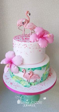 a three tiered cake decorated with pink flowers and flamingos