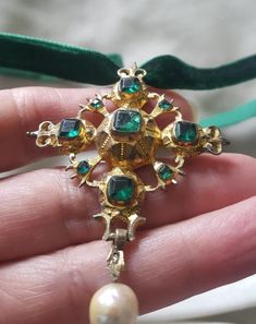 I always maintain that a cross is a dramatic piece of jewellery. This one is high grade silver (unmarked and tested) and is gilded in gold. The pendant is 2 1/4 inches long by 1 3/4 inches wide. It is beautifully designed with emerals green flat cut pastes and had a pearl drop. The bubble back it typical of this period and the gold gilding has worn with centuries of wear. The center stone is cracked but appears to be stable. C. 1720 and Spanish. Follow me on instagram2jettesjewels. Wedding Jewelry With Cross Pendant, Luxury Crucifix Cross Necklace For Formal Occasions, Luxury Formal Cross Pendant Necklace, Gold Crucifix Jewelry Collectible, Collectible Gold Crucifix Jewelry, Gold Cross Jewelry With Large Pendant, Victorian Cross Necklace For Formal Occasion, Antique Cross Pendant Necklace For Formal Occasions, Ornate Cross Pendant Jewelry For Formal Occasions