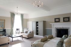 a living room filled with furniture and a fire place in the middle of it's walls