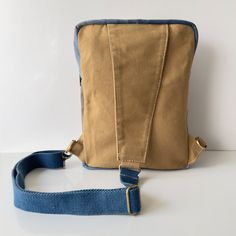 a brown and blue bag sitting on top of a white table