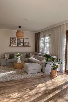 a living room filled with furniture next to a window covered in curtains and drapes