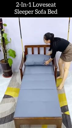 a woman is bending over to pick up the mattress on top of the bed that's in front of her