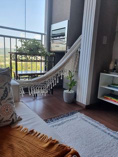 a hammock sitting on top of a wooden floor next to a window