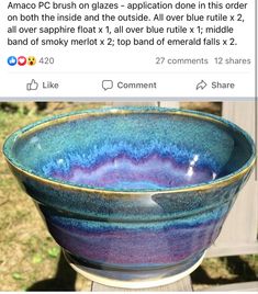 a blue and purple bowl sitting on top of a wooden table