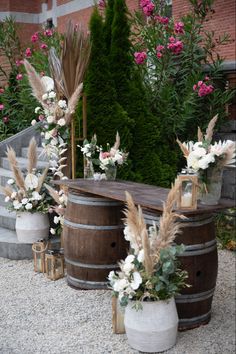 an outdoor ceremony setup with flowers and pamodia in vases on the ground