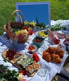 a table filled with food and flowers on top of a grass covered field