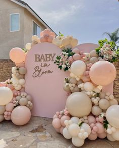 balloons and flowers decorate the entrance to a baby shower