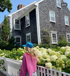 a woman standing in front of a house