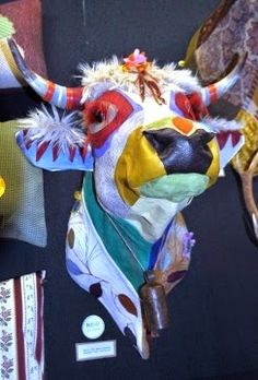 a bull head hanging from the side of a wall with other items on display behind it