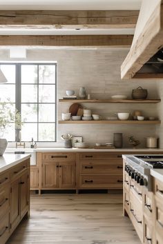 a large kitchen with wooden cabinets and open shelving on the wall above the stove