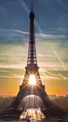 the eiffel tower is lit up at sunset