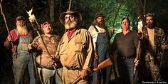 a group of men standing next to each other in the woods with long beards