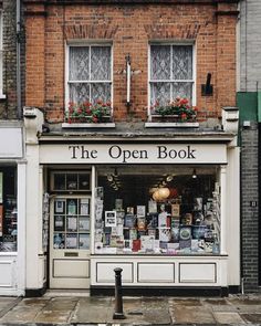 an open book store on the corner of a street in front of a brick building