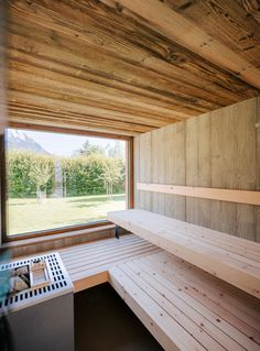 an empty sauna with wooden walls and benches in front of a large open window