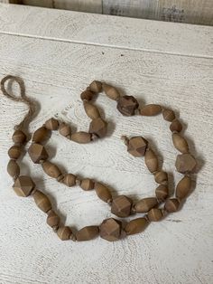 a necklace made out of wood beads on a white surface with a string attached to it