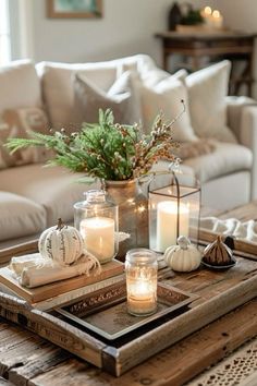 a tray with candles on top of it next to a white couch and coffee table