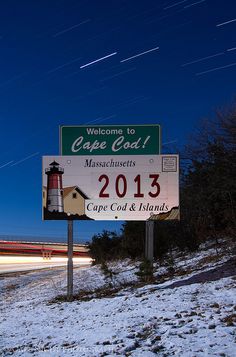 a welcome sign to cape coast massachusetts with the lighthouse in the background and stars streaking overhead