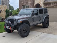 a gray jeep parked in front of a house