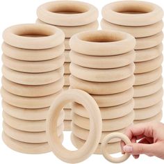 a stack of wooden rings with one being held by a hand