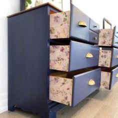 a blue dresser with floral drawers on it