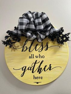 a yellow plaque with black and white plaid bows on it that says, bliss all who gather here