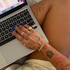 a woman with tattoos on her arm using a laptop