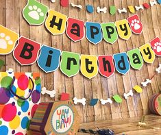 a happy birthday banner is hanging on the wall next to a dog themed party decoration