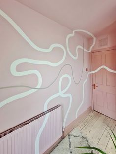 an empty room with pink walls and white lines painted on the wall, along with a radiator