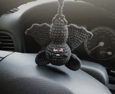 a crocheted stuffed animal hanging from the dash board of a car's dashboard