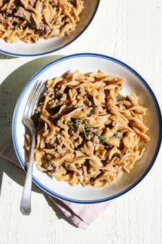 two plates of pasta with mushrooms and parsley