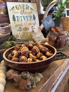 a bowl full of nuts sitting on top of a wooden table next to other items