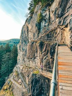 a person walking across a wooden bridge over a canyon